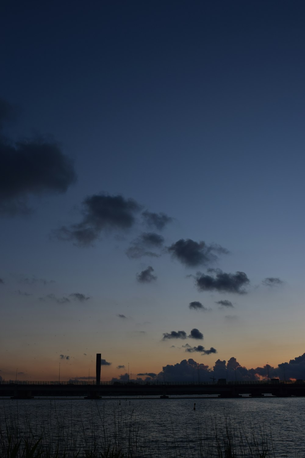 a large body of water with a sky in the background