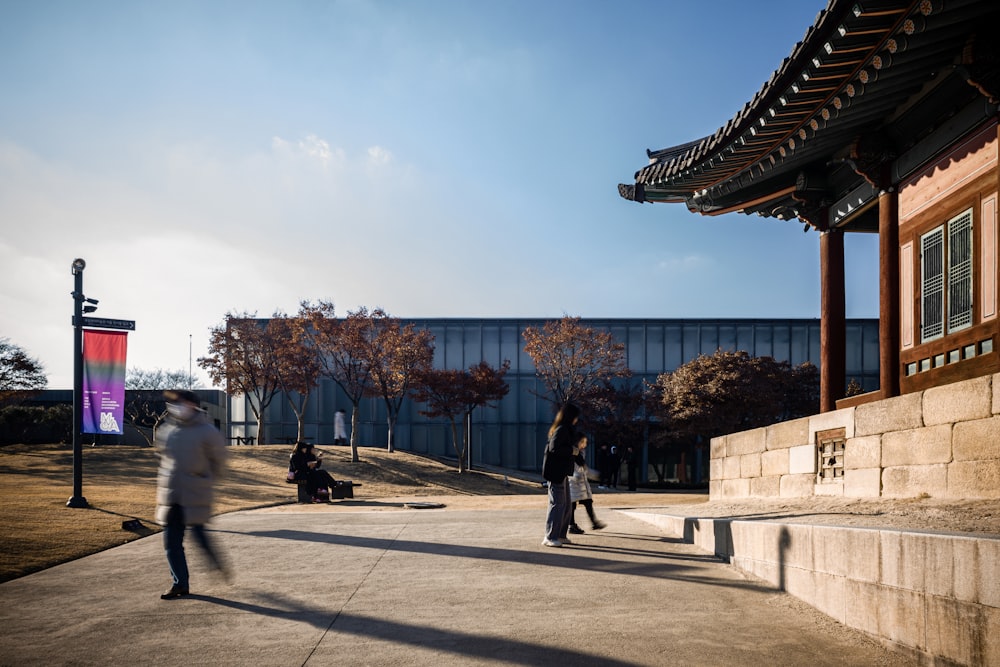 a group of people walking around a building