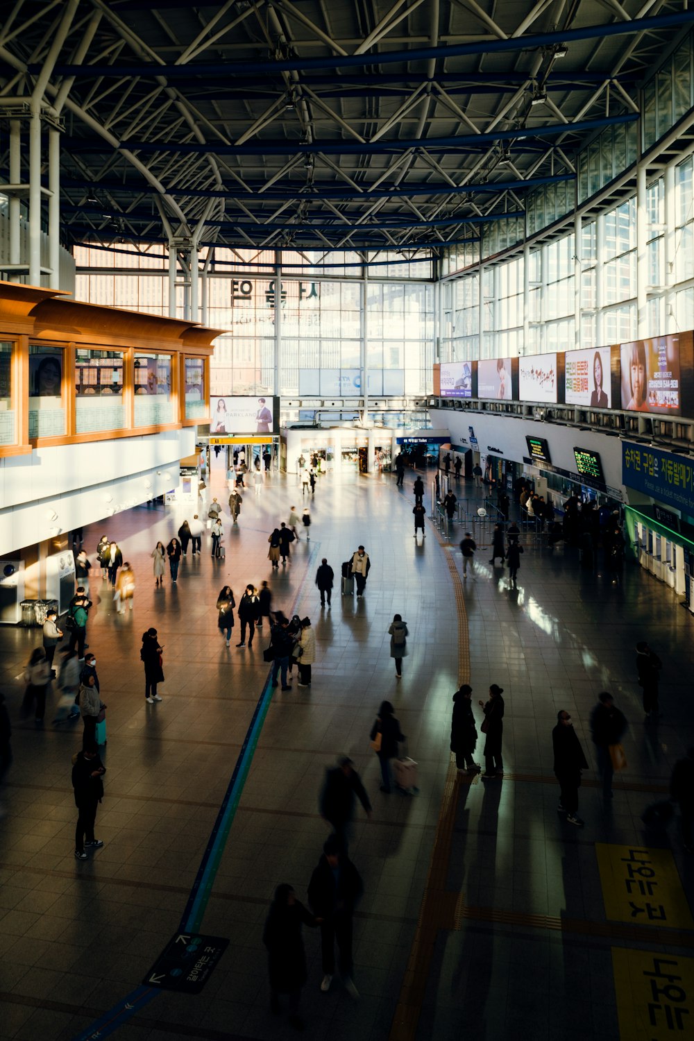 a group of people walking around a train station