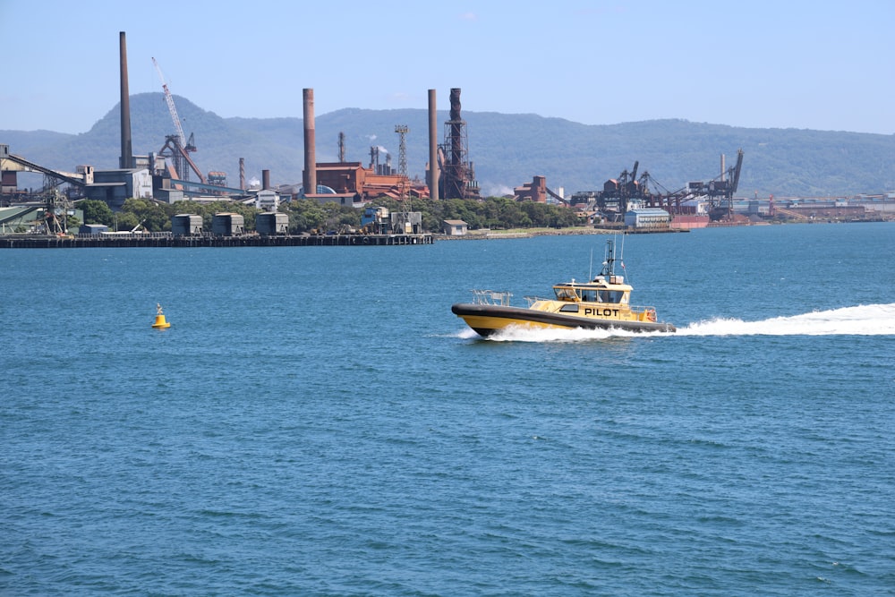 a yellow boat traveling across a large body of water