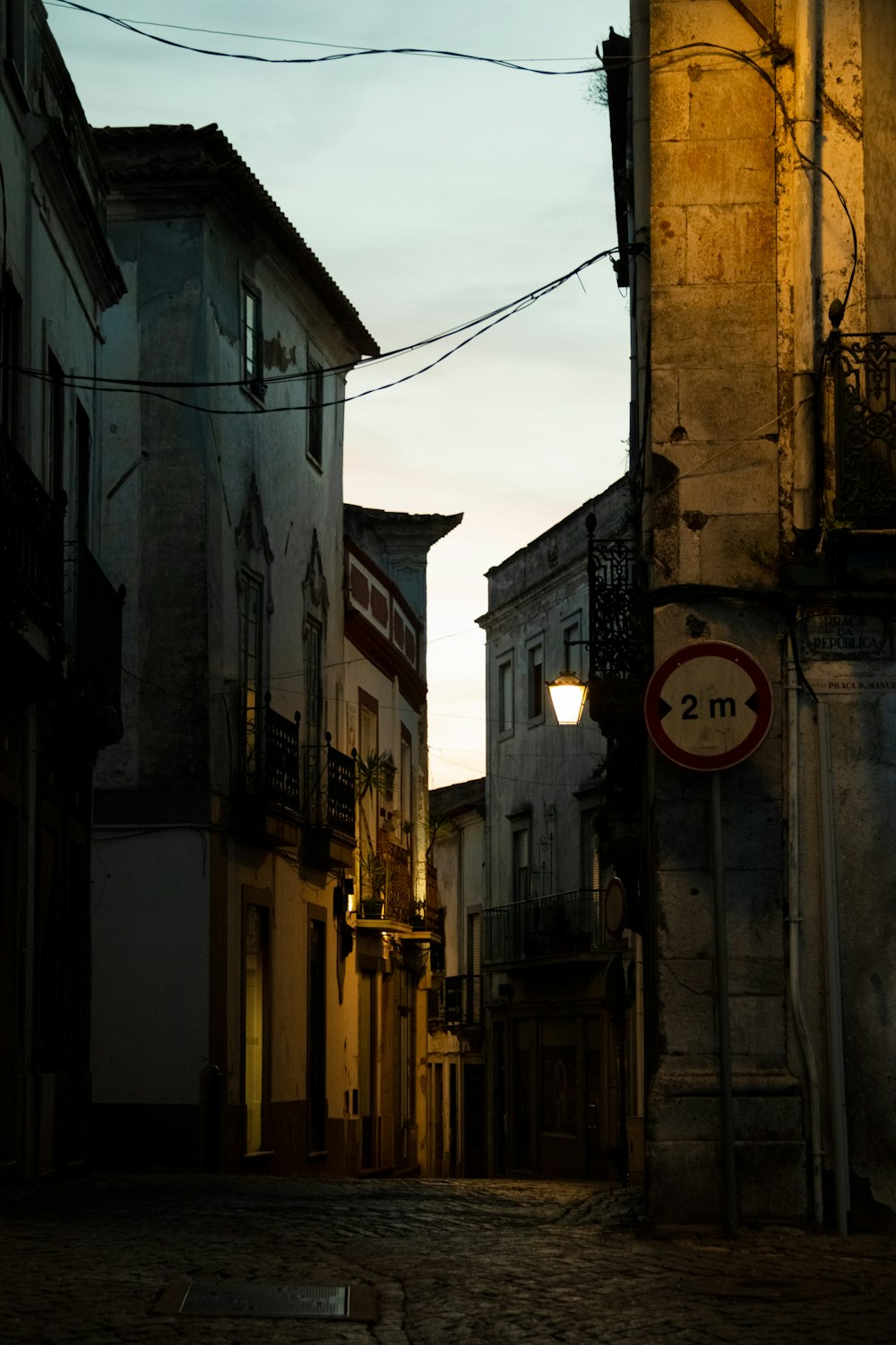 a dark alley way with a street sign and buildings