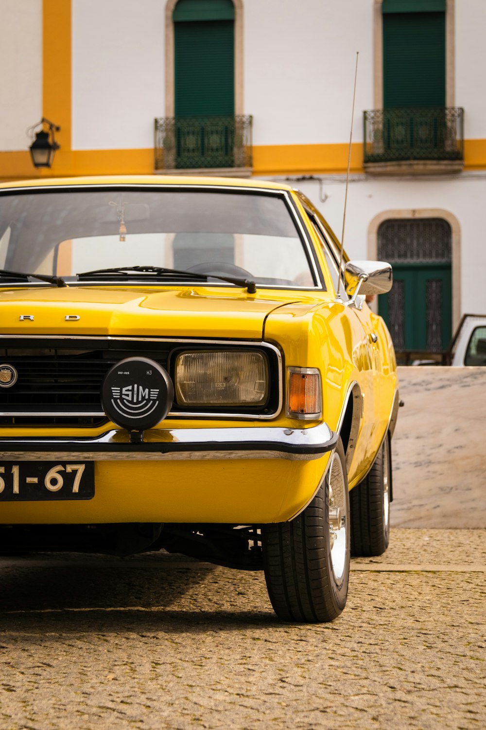 a yellow car parked in front of a building