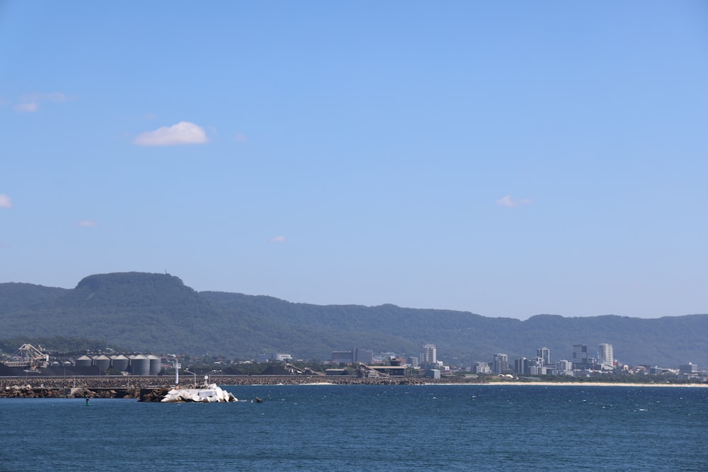 a large body of water with a city in the background