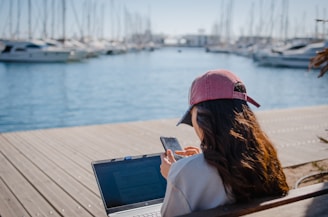 a woman sitting on a bench using a laptop computer