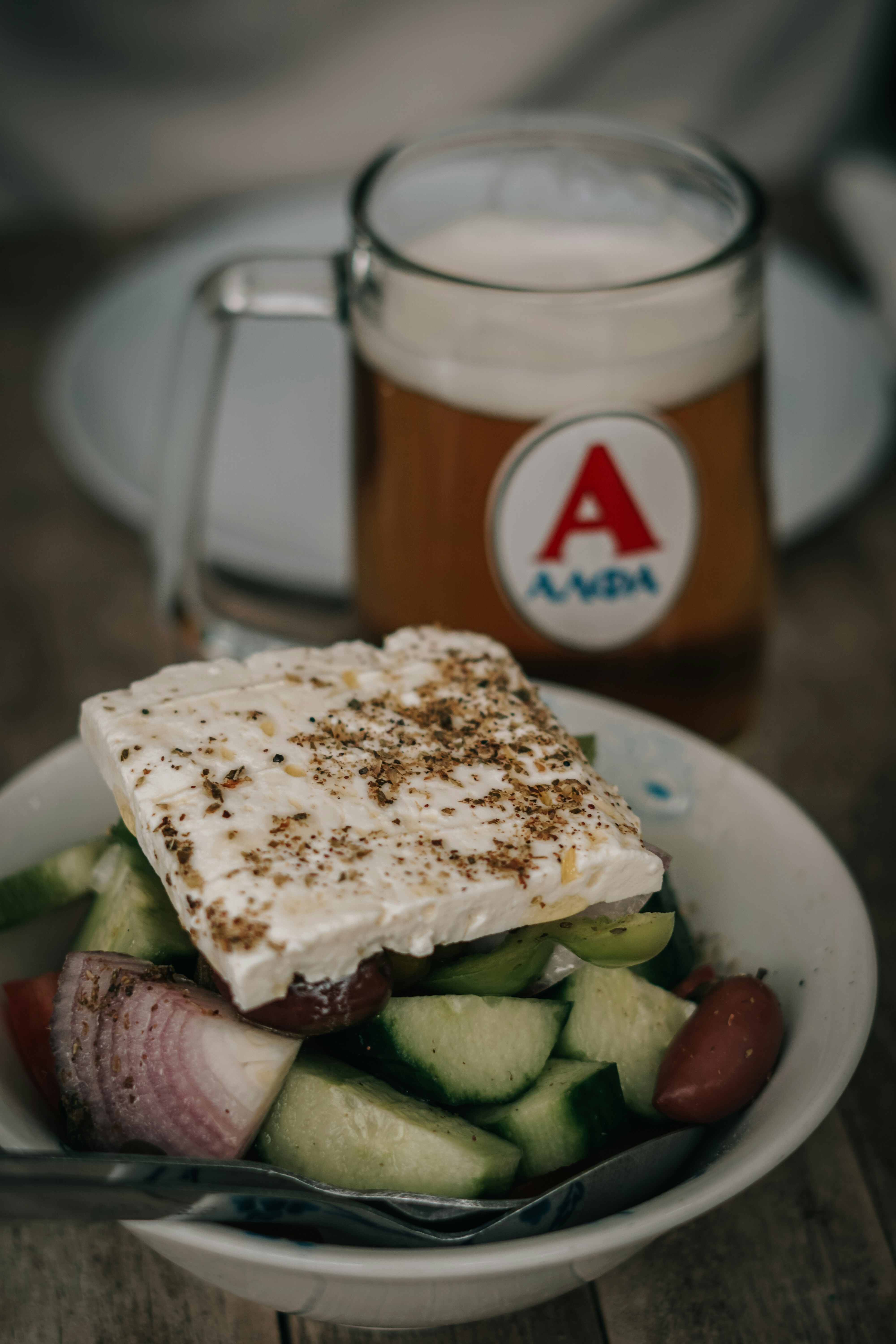 un cuenco de comida y un vaso de cerveza sobre una mesa
