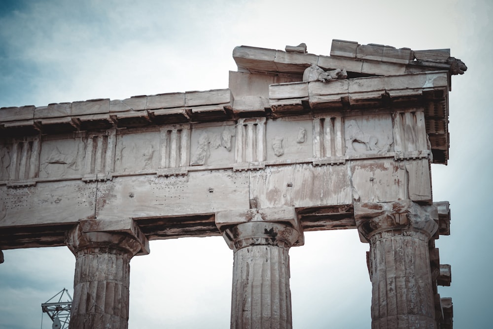 a large stone structure with columns and a sky background