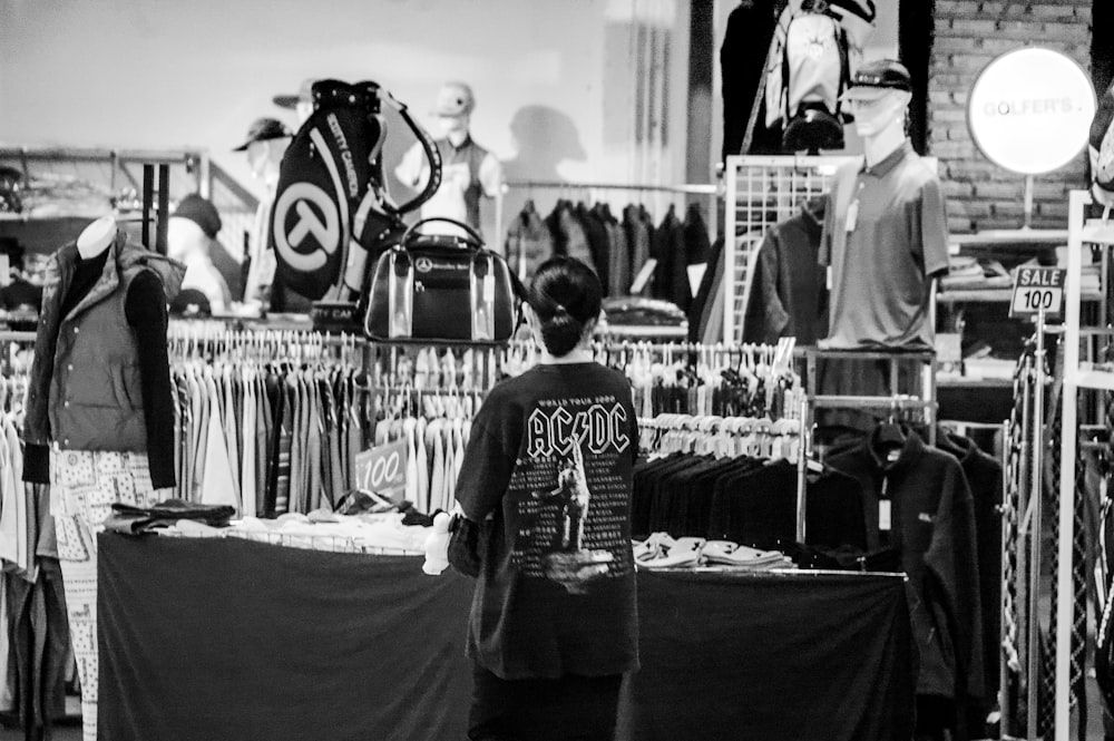 a black and white photo of a man in a clothing store