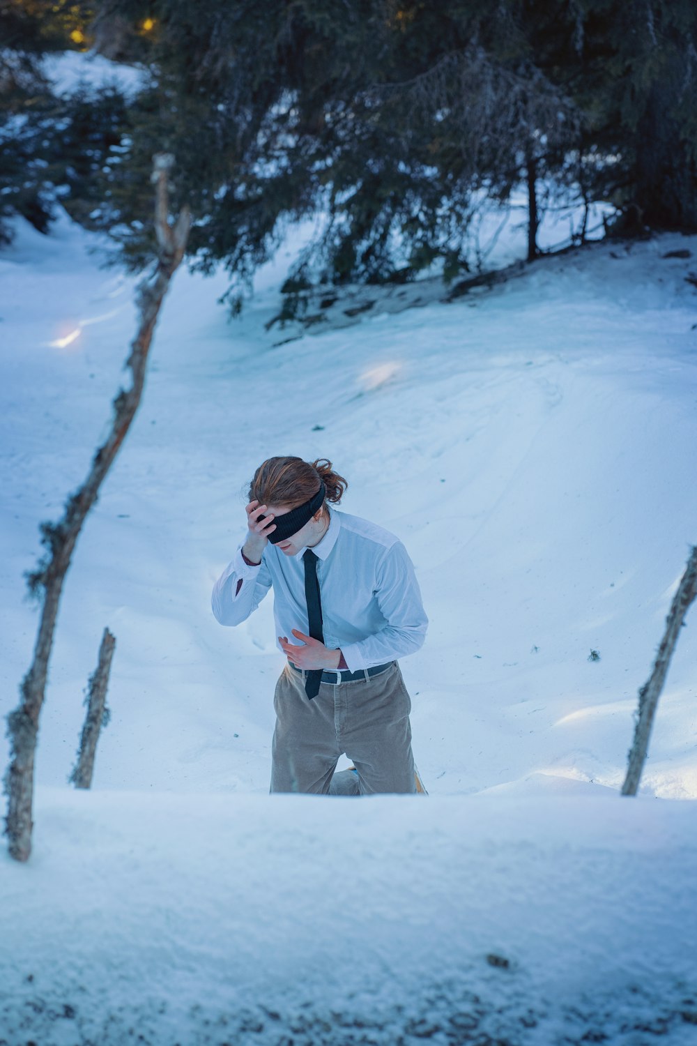 a man standing in the snow wearing a tie