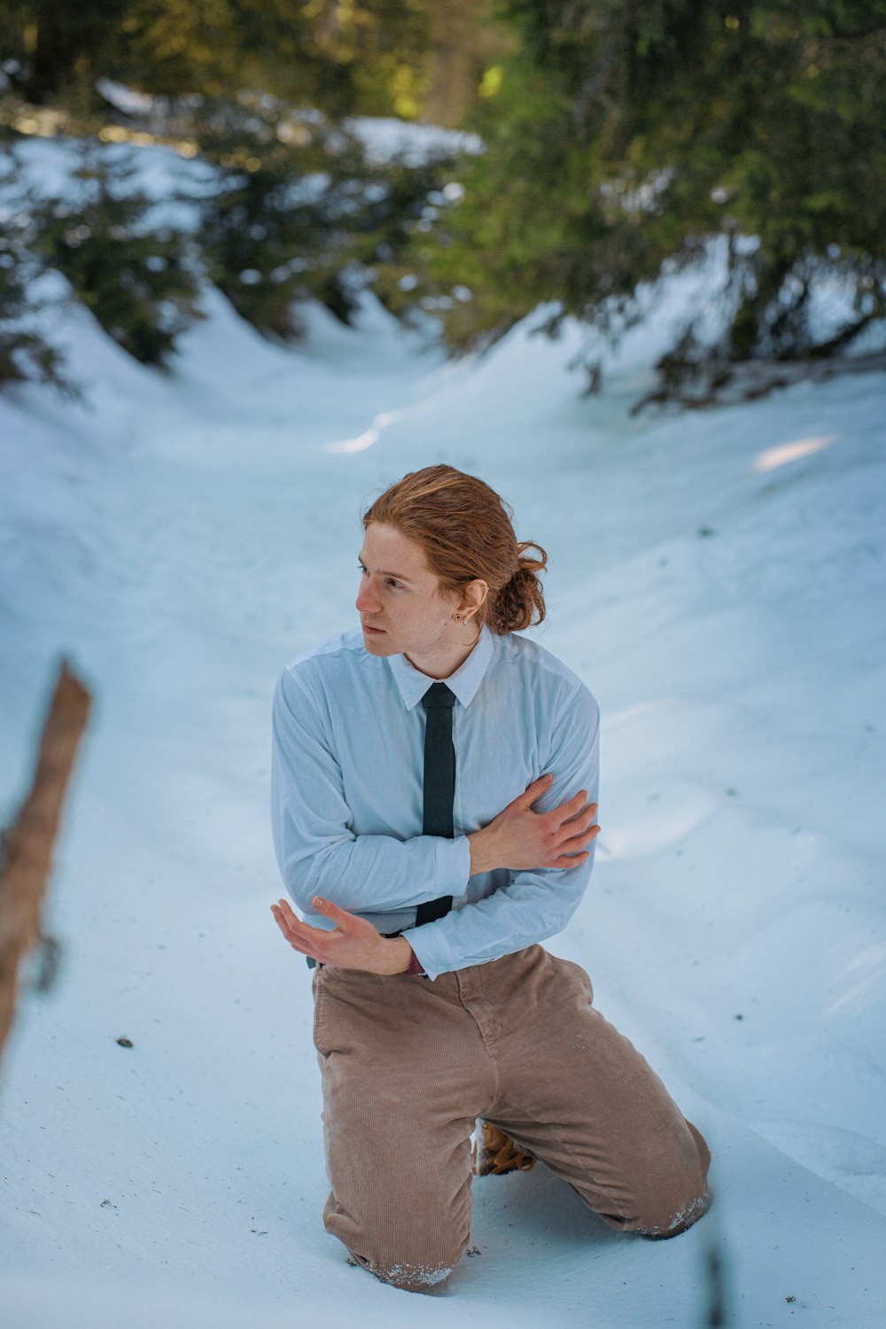 a woman sitting in the snow with her arms crossed