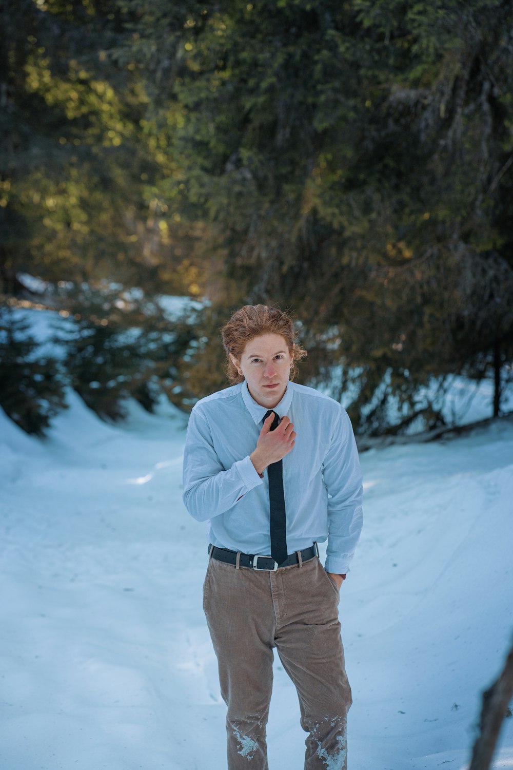 a man in a tie standing in the snow