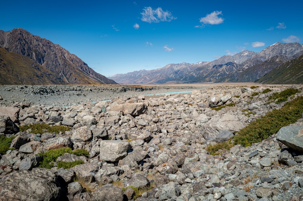 a rocky landscape with mountains in the background