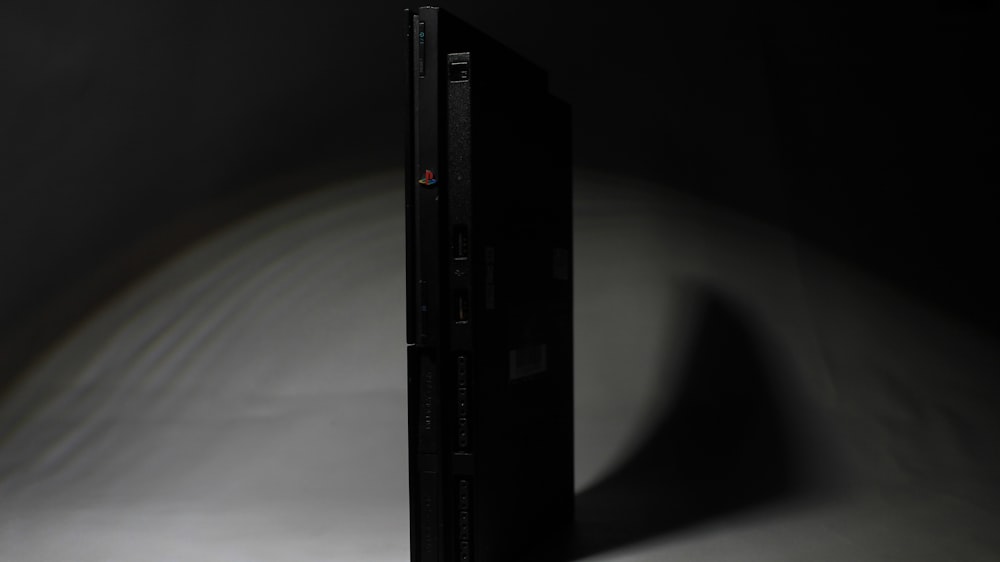 a black video game console in the dark
