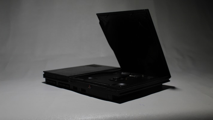 a black laptop opened up on a white surface