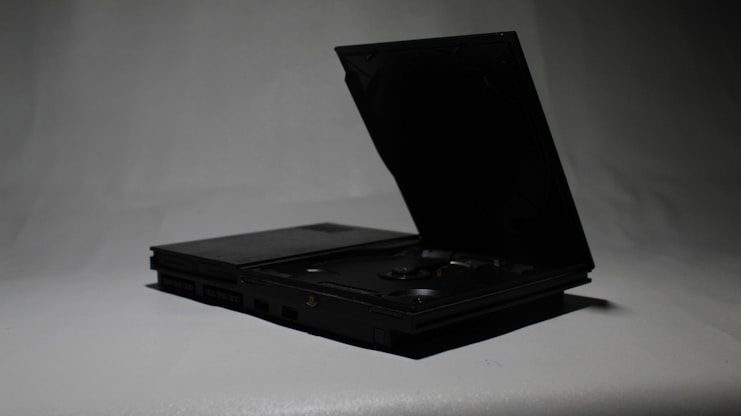 a black laptop opened up on a white surface