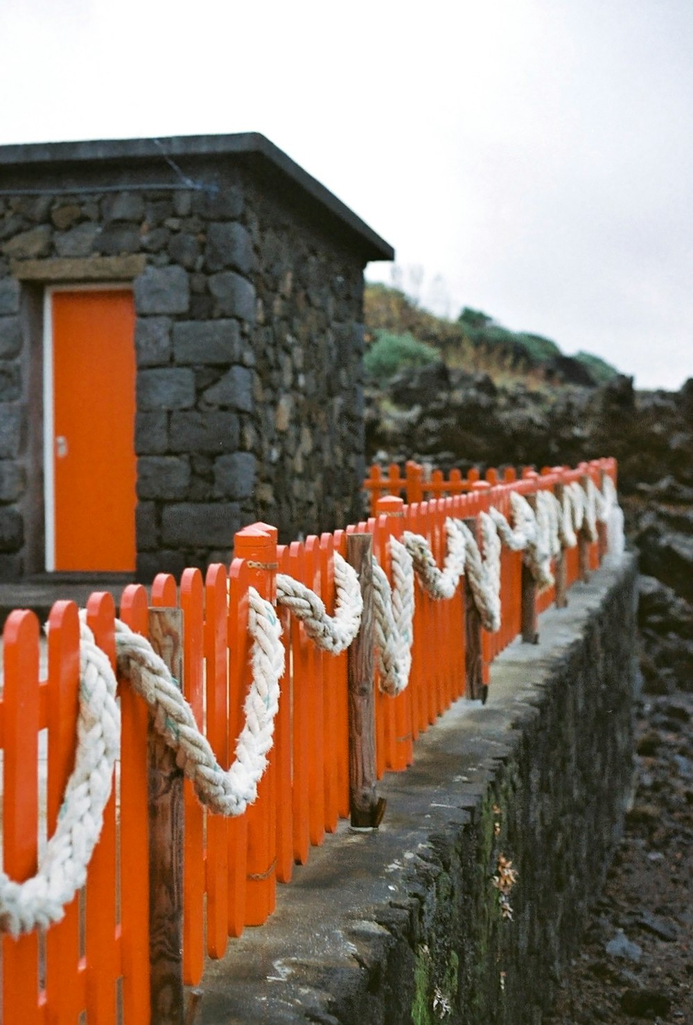 a row of orange and white ropes next to a building