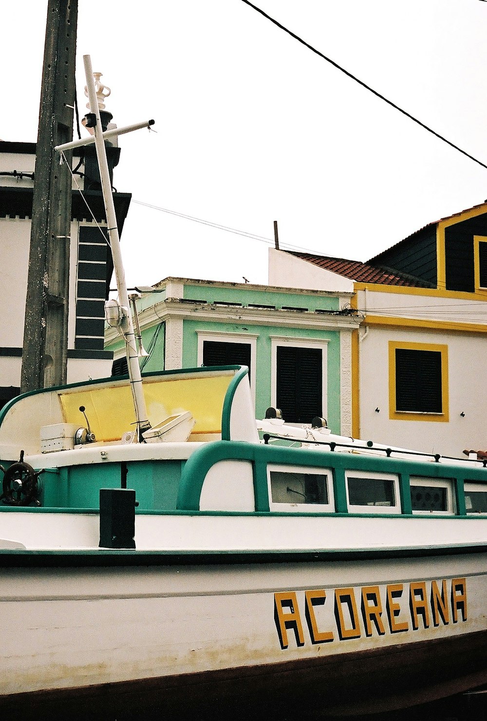un bateau vert et blanc garé devant un immeuble