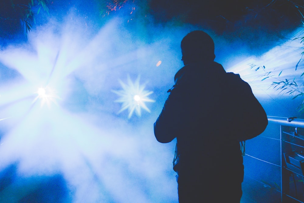 a man standing in front of a blue light