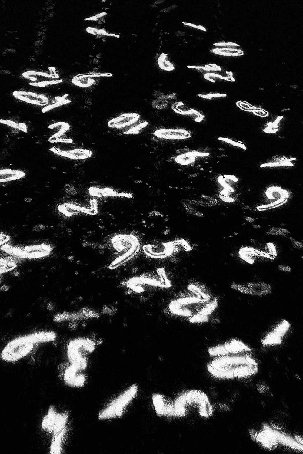 a black and white photo of numbers on the ground