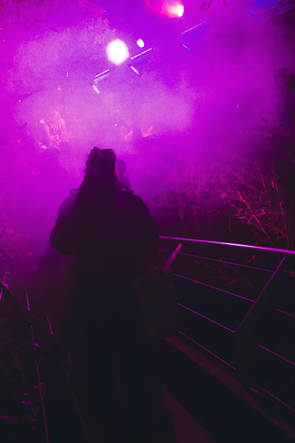 a person standing in front of a purple light