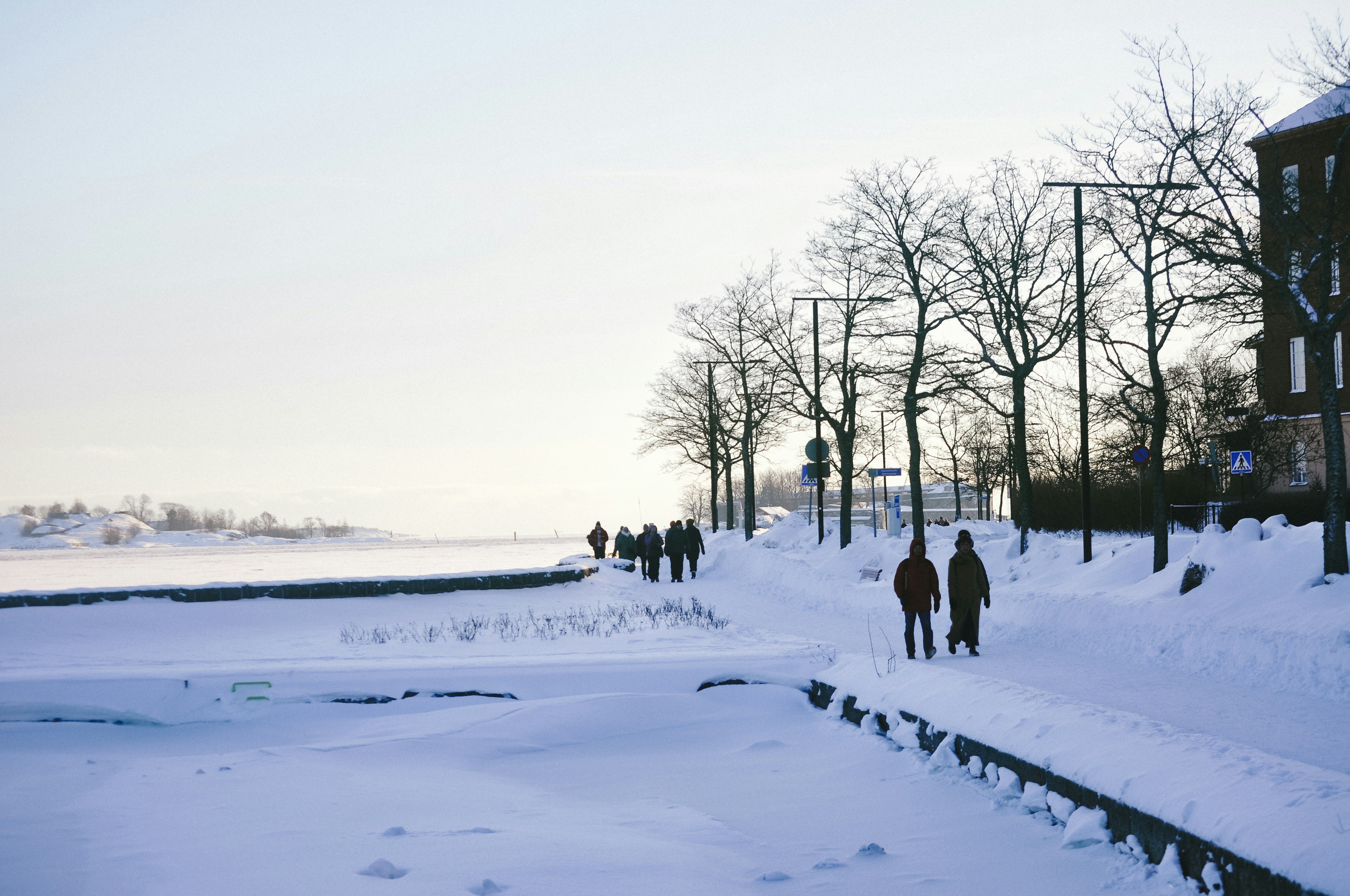 a group of people walking down a snow covered sidewalk