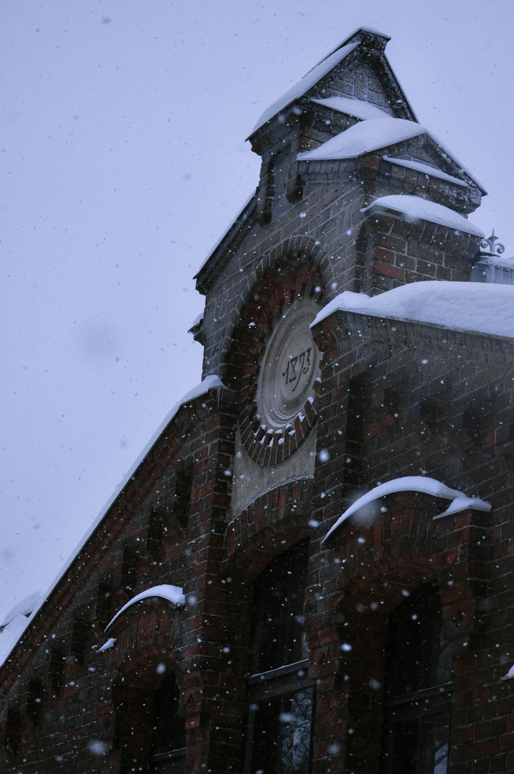 a clock tower covered in snow on a snowy day