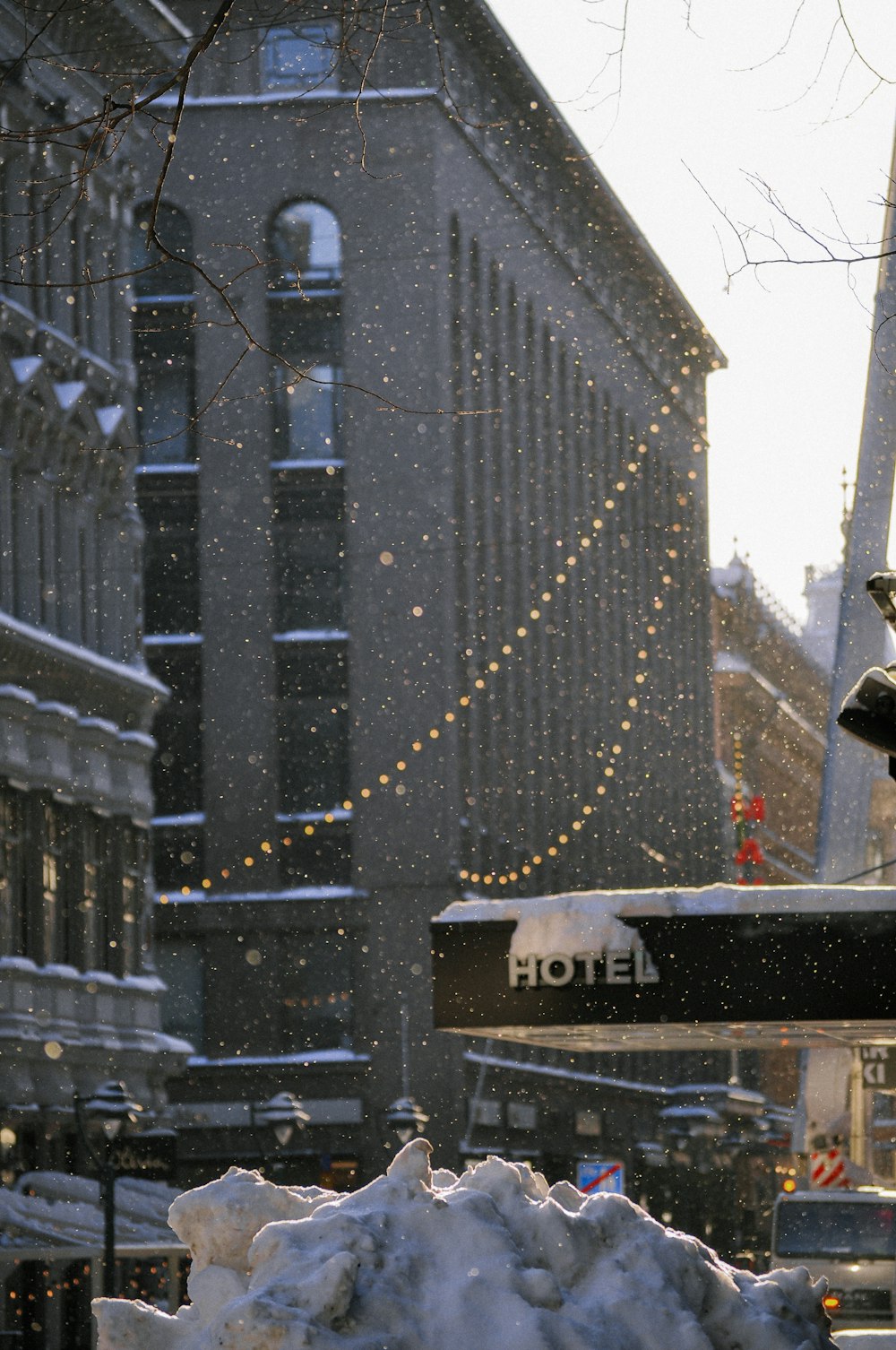 a hotel sign is covered in snow on a city street