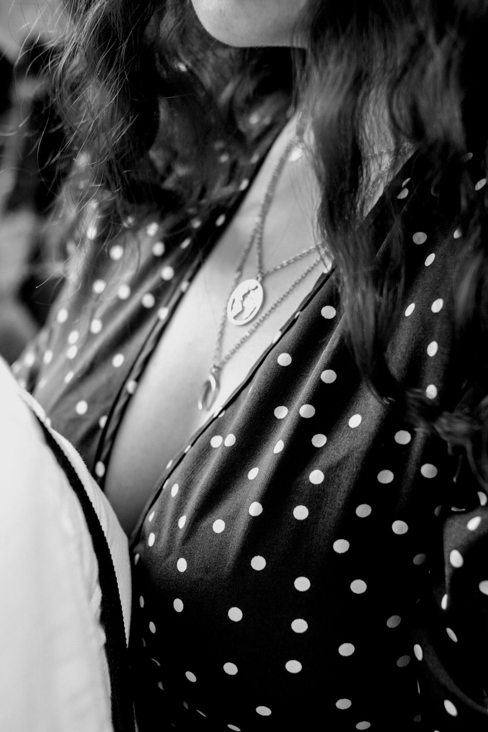 a woman wearing a polka dot shirt and a necklace