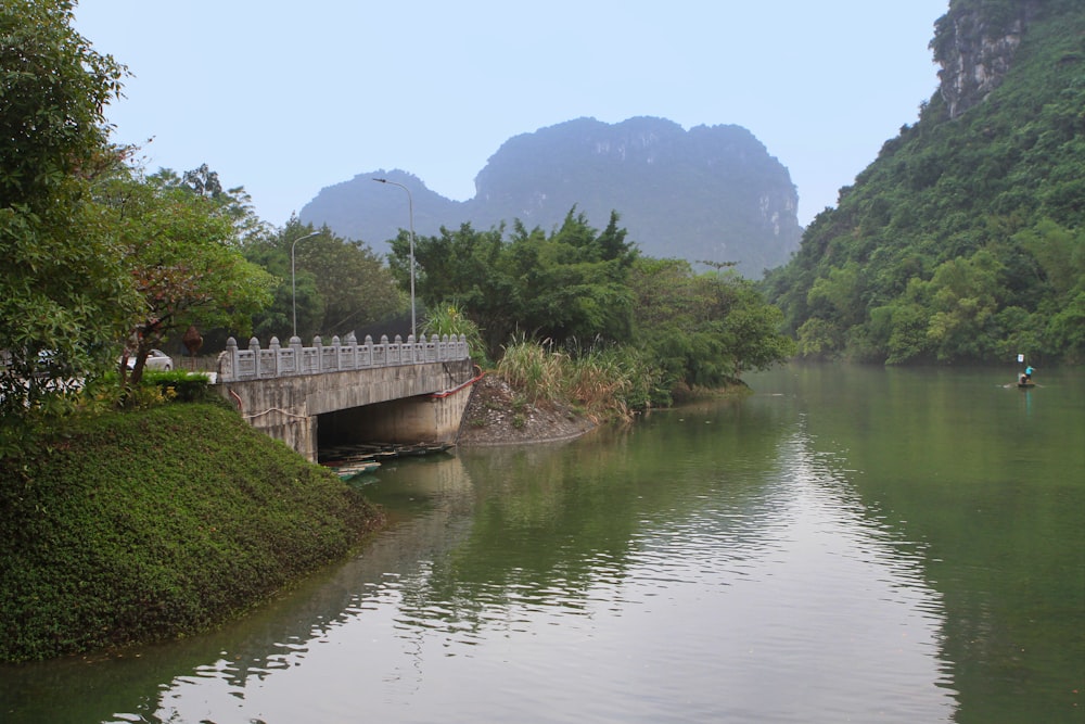 un pont au-dessus d’un plan d’eau entouré de montagnes