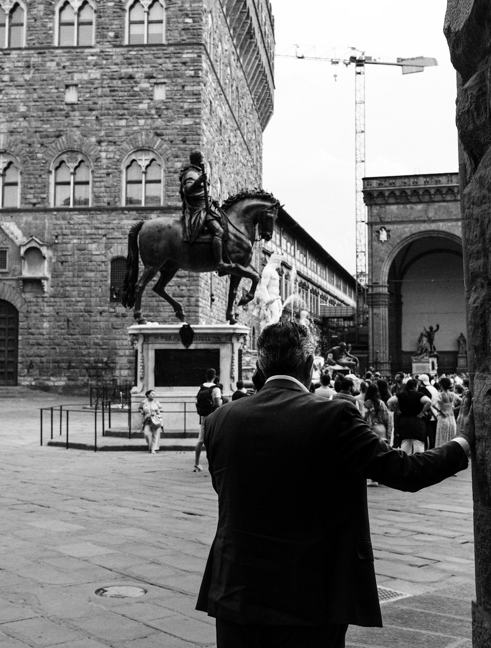 a man standing next to a statue of a man on a horse