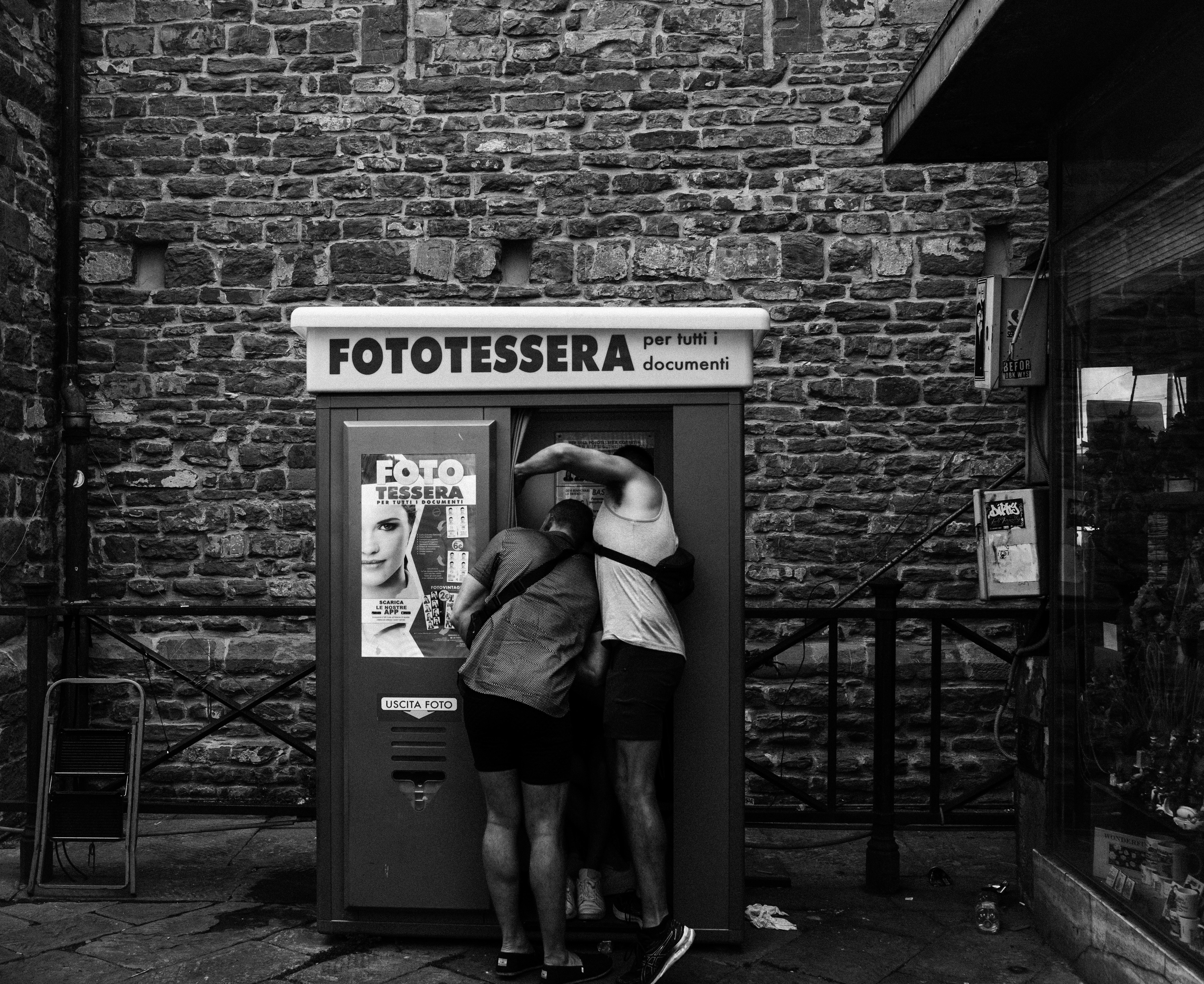 a couple of people that are standing in front of a phone booth