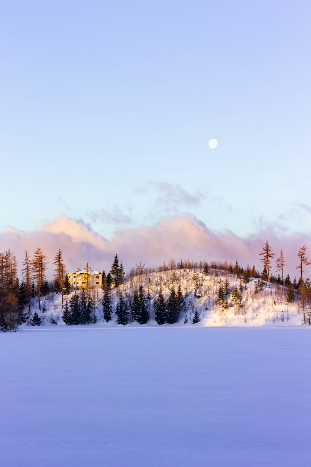 a snow covered hill with a house on top of it