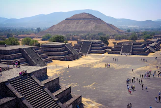 a group of people standing in front of a pyramid