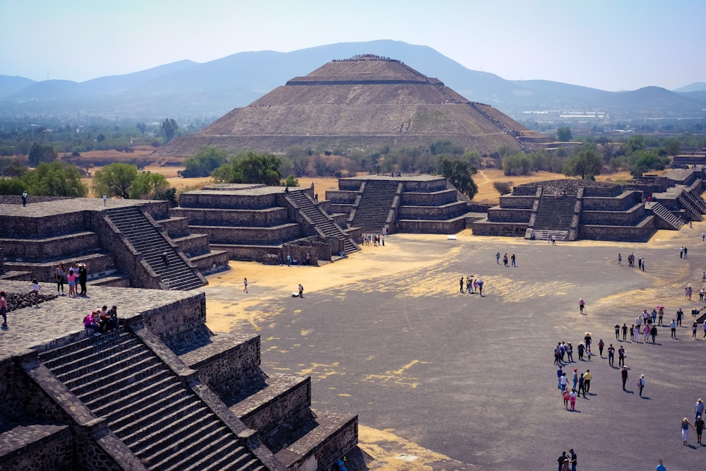 a group of people standing in front of a pyramid