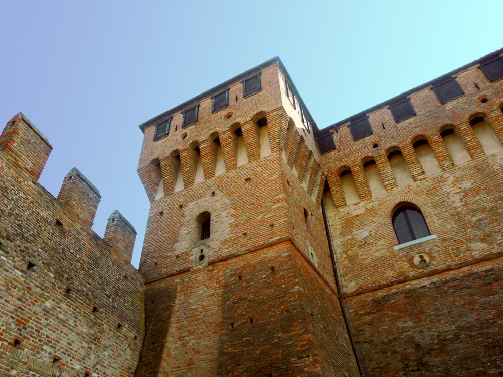 a very tall brick castle with a clock on it's side