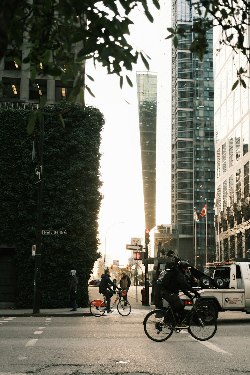 a man riding a bike down a street next to tall buildings