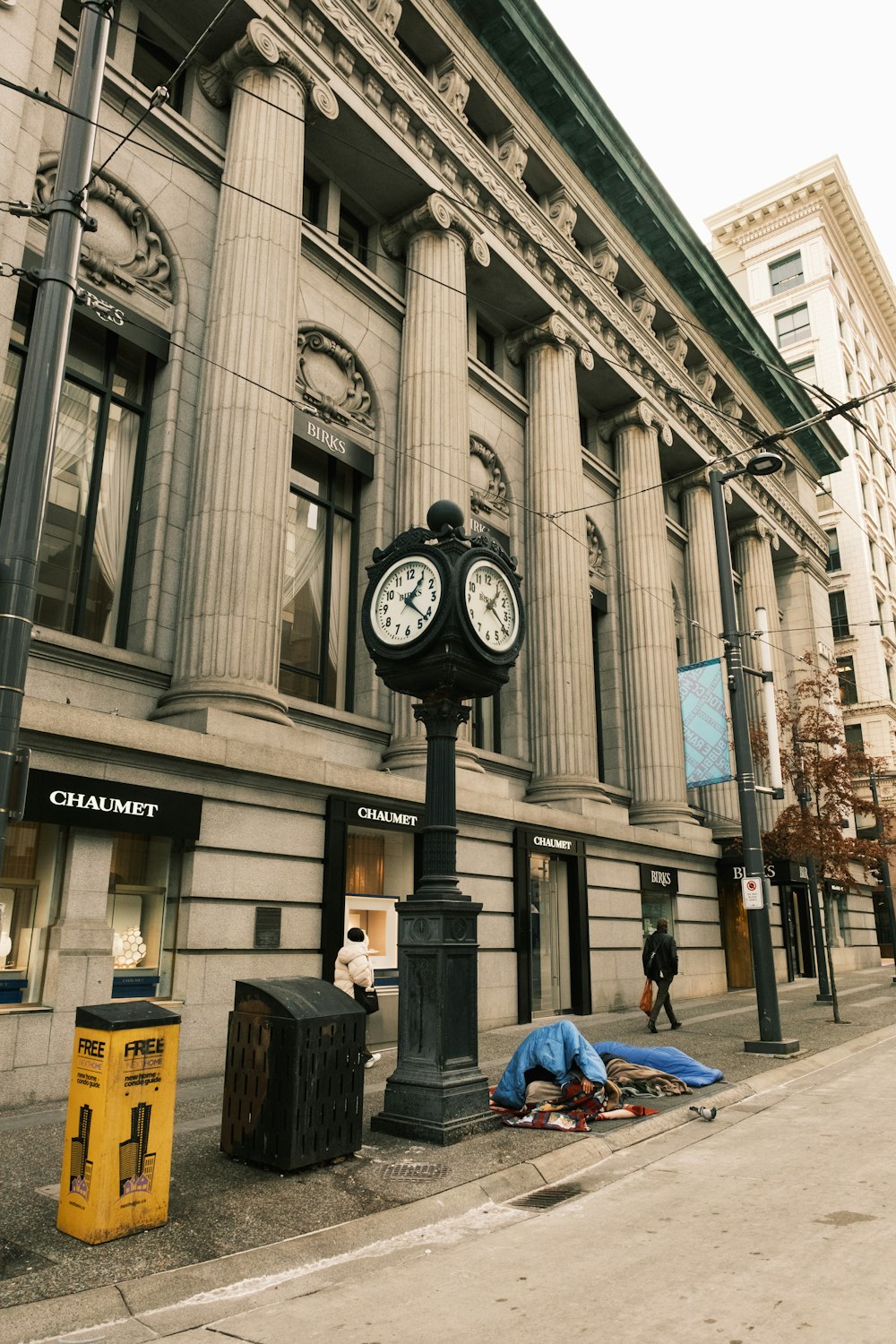 a clock on a pole in front of a building