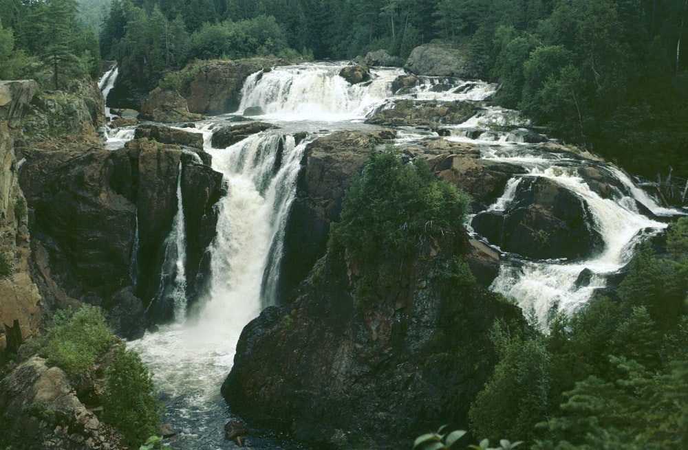 une grande cascade entourée d’arbres et de rochers