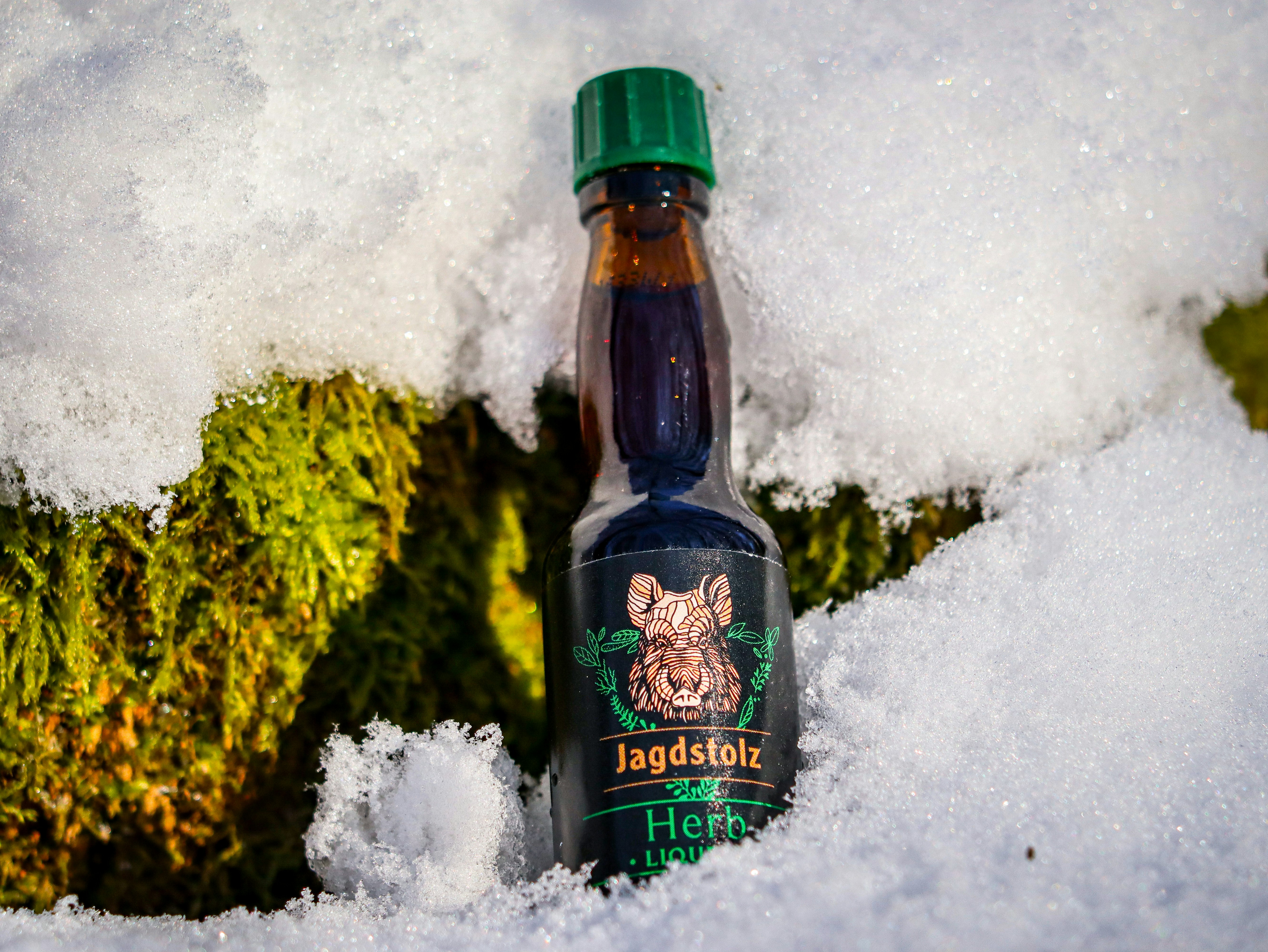 a bottle of liquid sitting in the snow