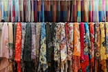 a rack of colorful scarves hanging on a wall