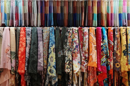 a rack of colorful scarves hanging on a wall