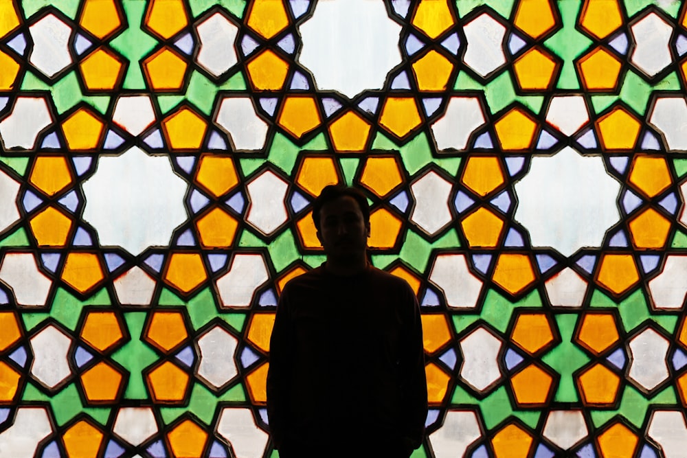 a person standing in front of a stained glass window