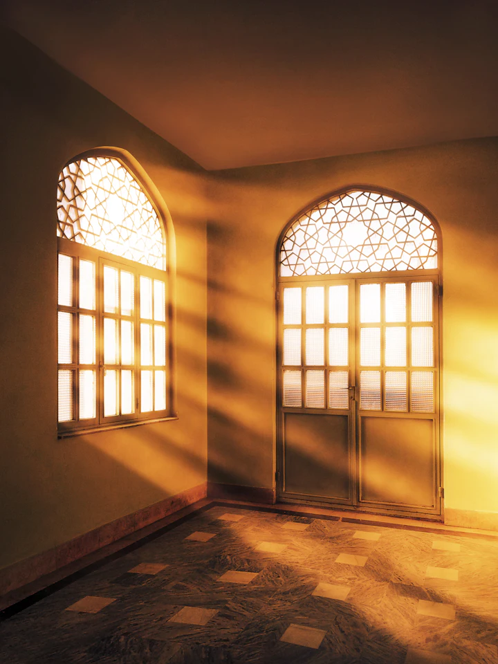 Empty room with two arched windows and a tiled floor