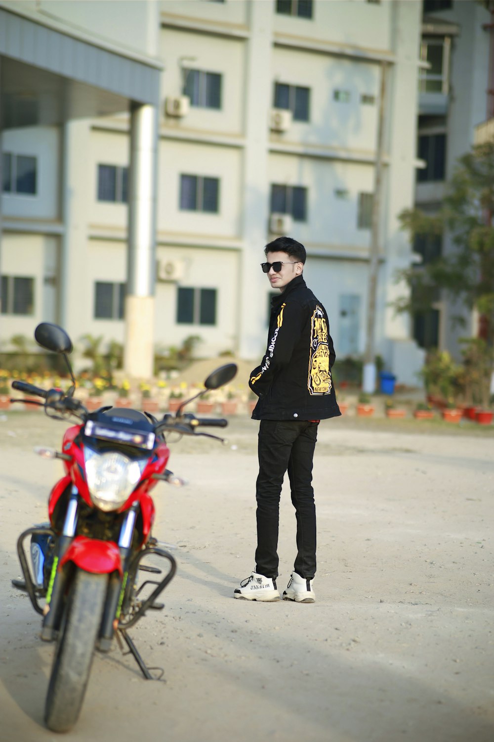 a man standing next to a motorcycle in front of a building