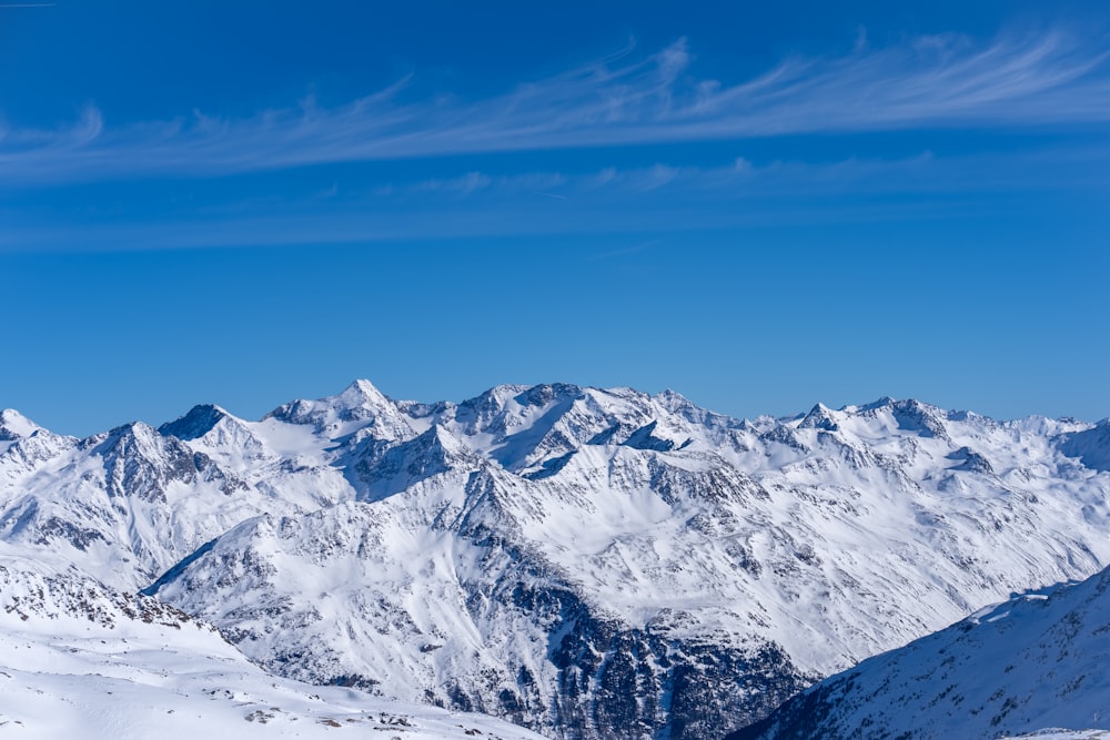 a view of a snowy mountain range from the top of a mountain