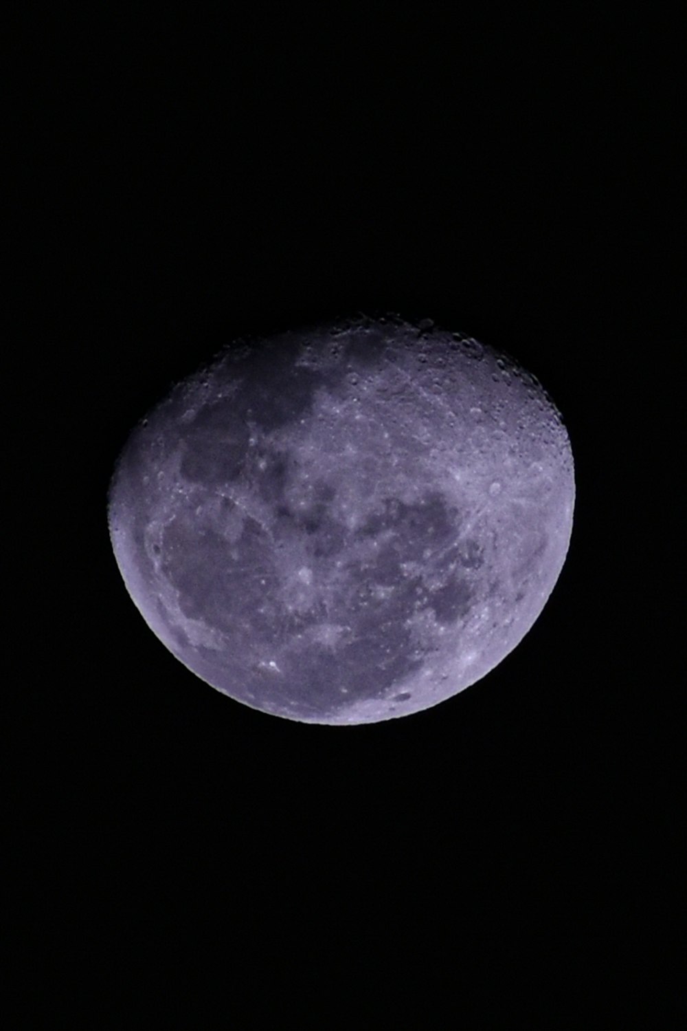 a full moon in the dark sky with a black background