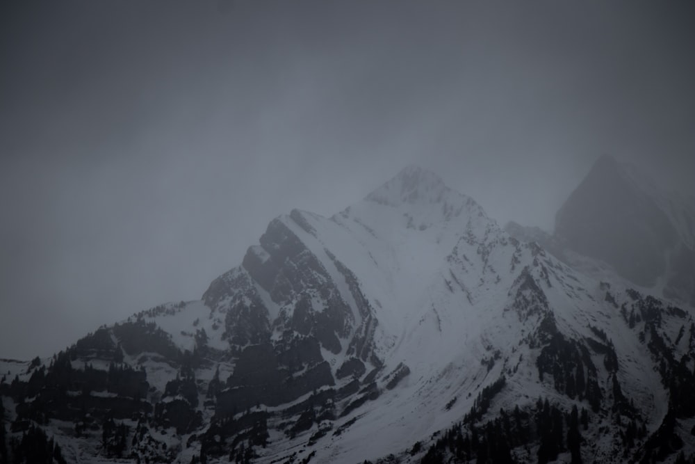 a mountain covered in snow and surrounded by trees