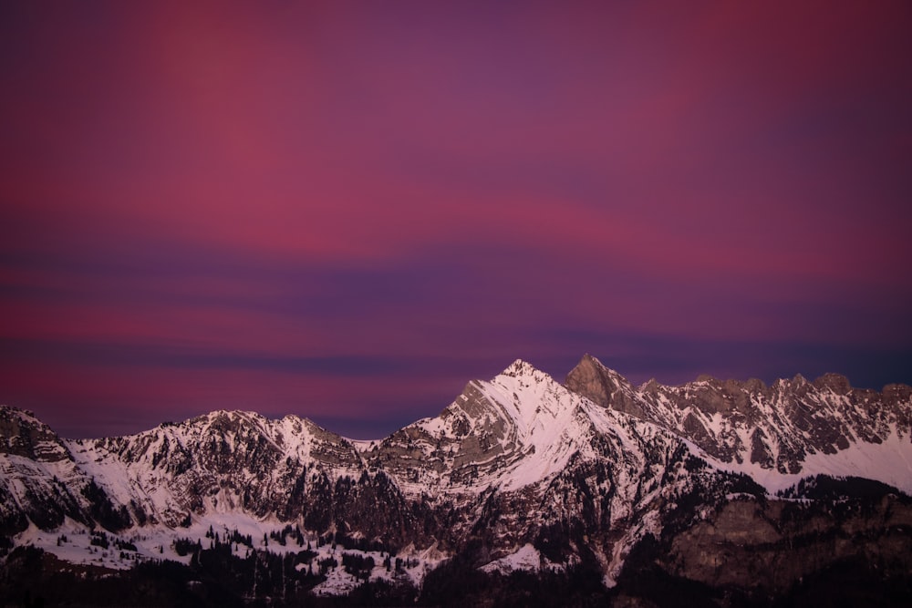 a view of a mountain range with a purple sky