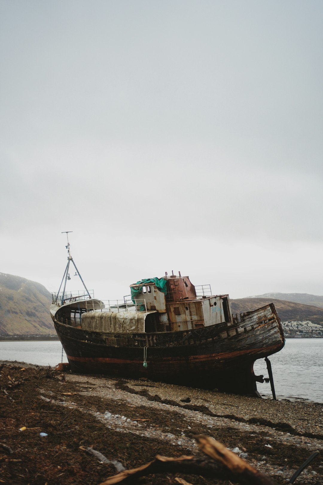 a rusted boat sitting on top of a beach