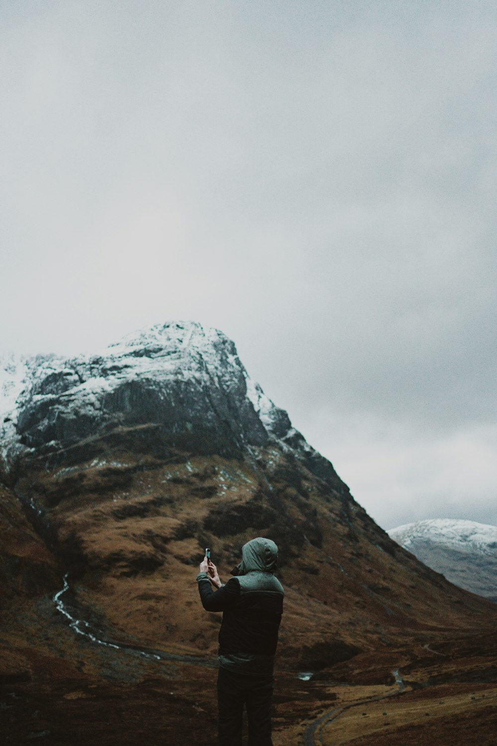 a person taking a picture of a mountain