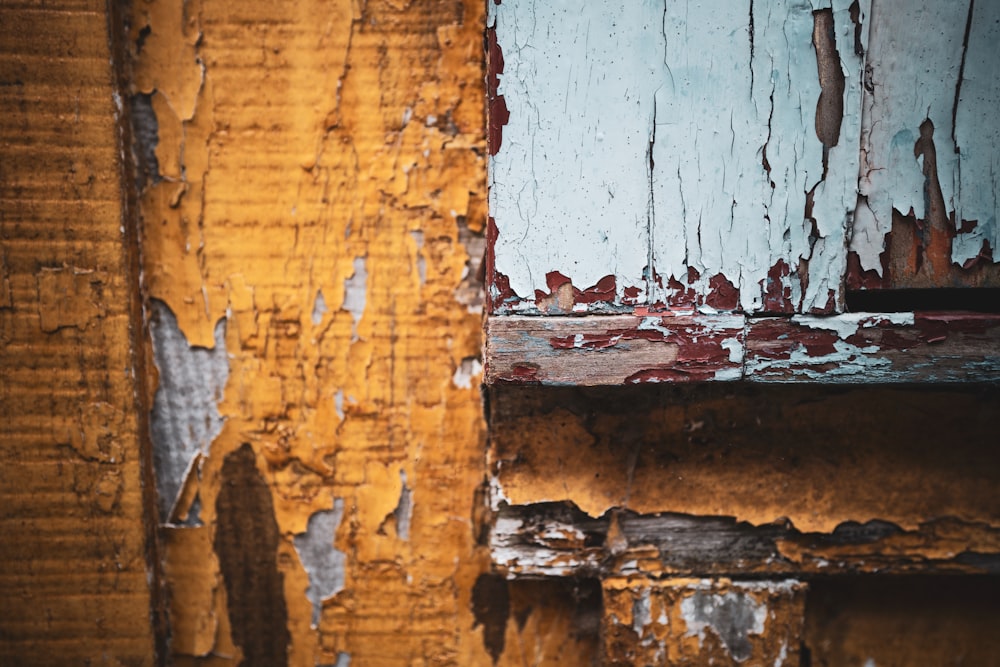 a close up of peeling paint on a wooden door